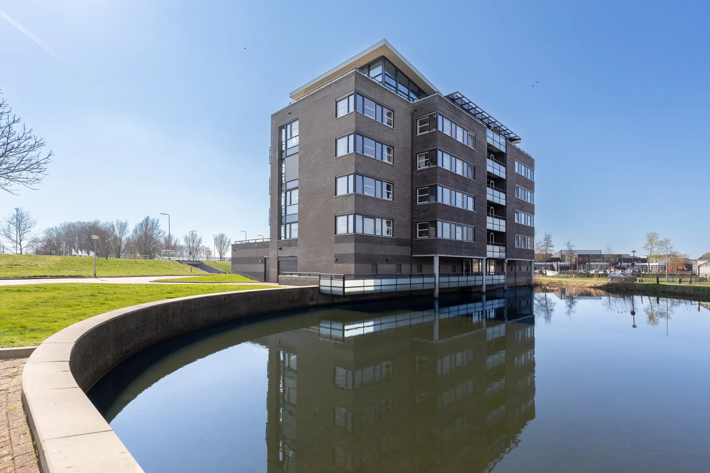 Appartementengebouw aan het water met weerspiegeling, vastgoedfotografie