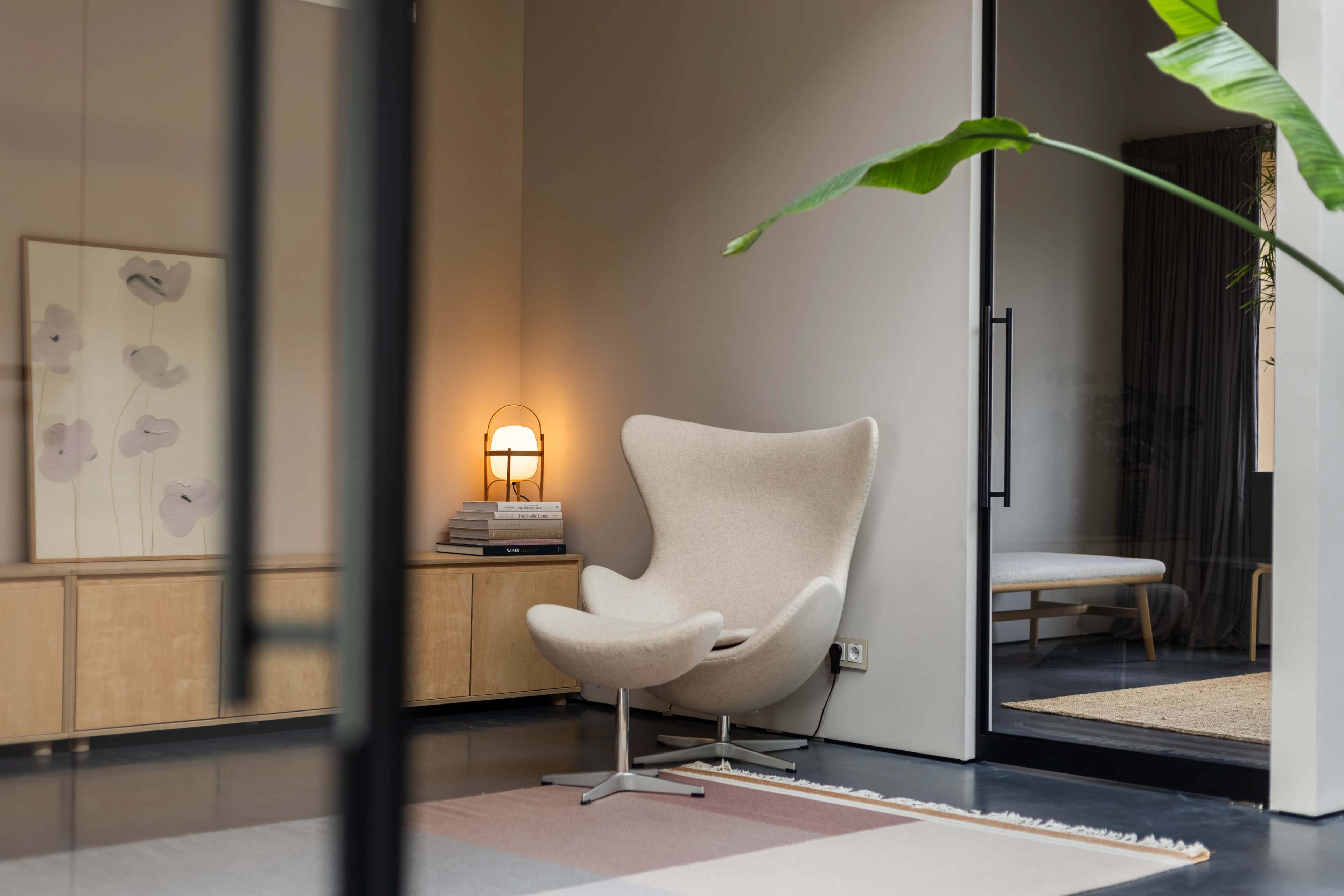 Design egg chair in modern interieur gezien door glazen wand, vastgoedfotografie