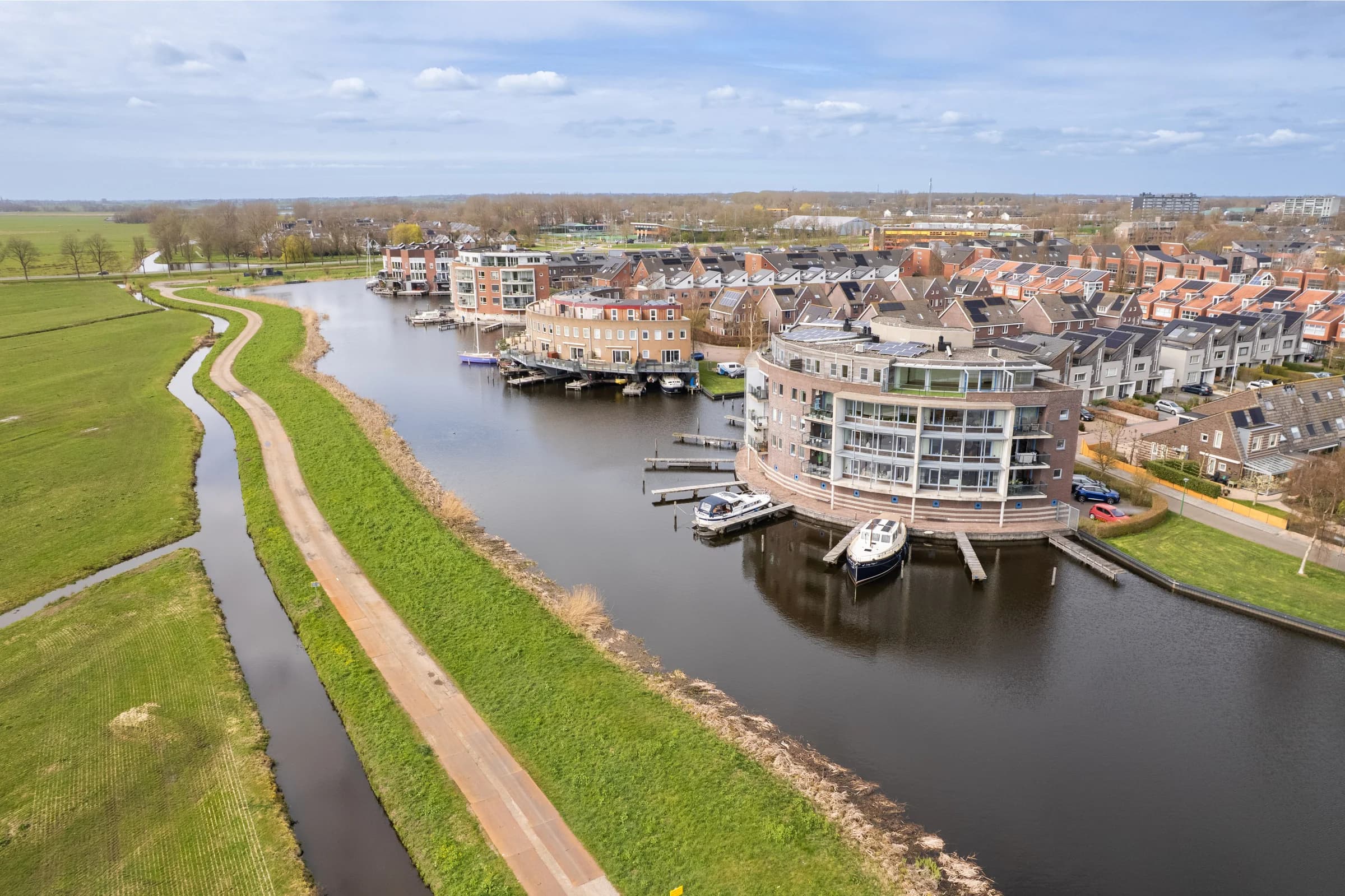 Drone-opname woningen langs de rivier, vastgoedfotografie Friesland