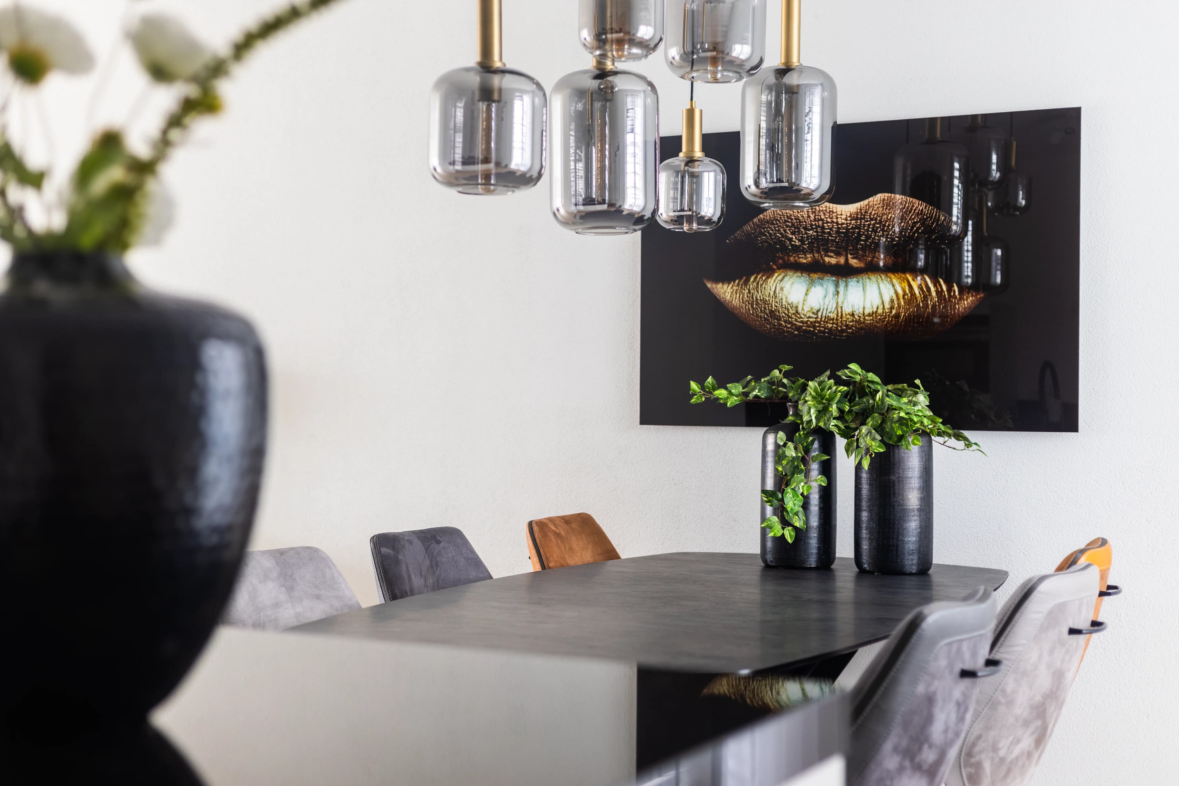 Moderne eetkamer met kunstwerk, glazen hanglampen en zwarte eettafel, vastgoedfotografie