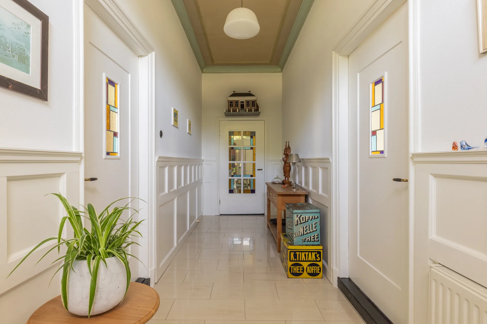 Karaktervolle entreehal met glas-in-lood deuren en vintage decoratie, interieur vastgoedfotografie