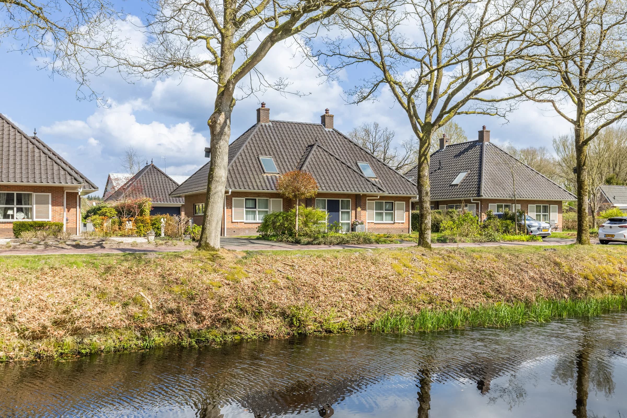Friese woningen langs sloot in voorjaar, vastgoedfotografie Friesland