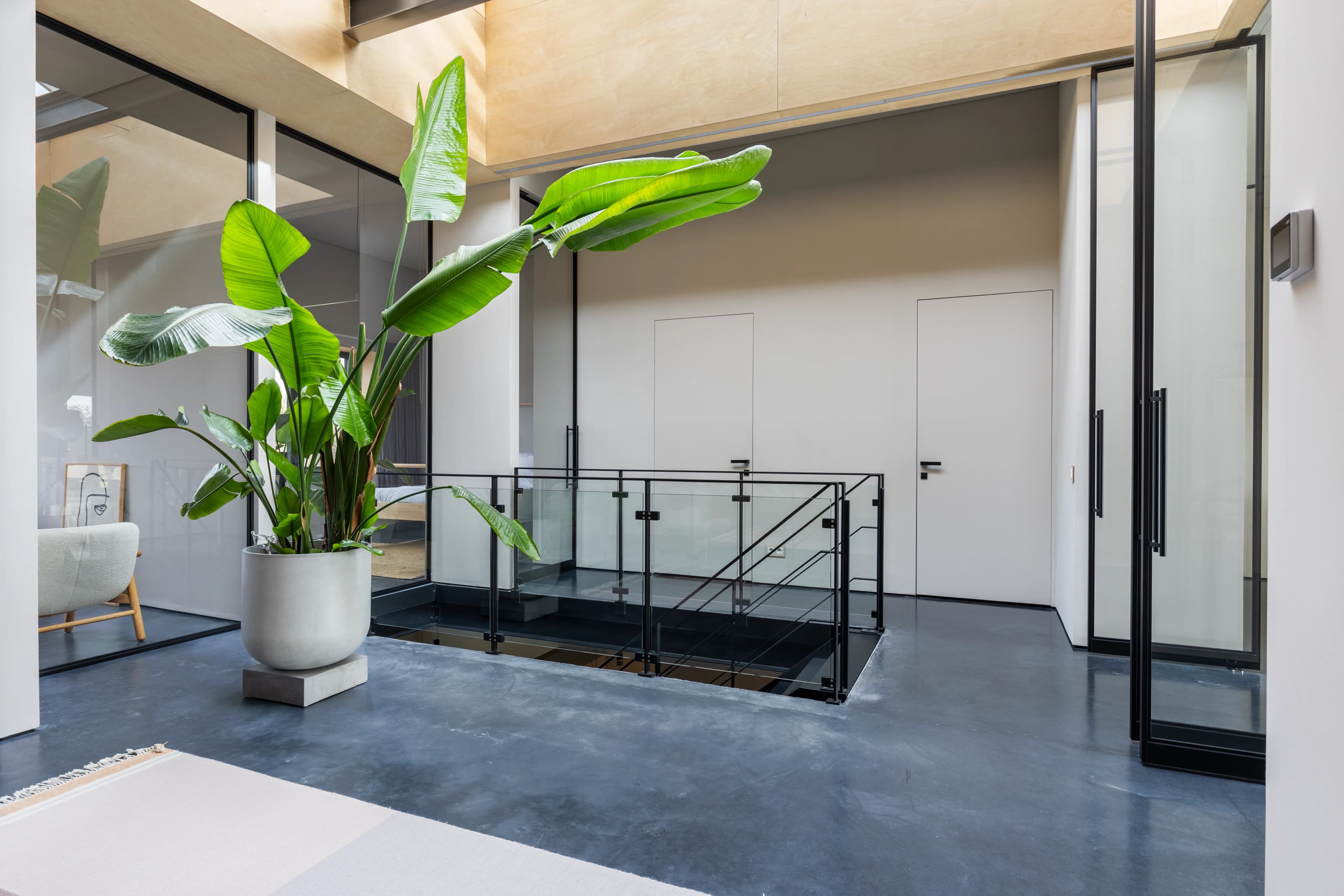 Open verdieping met glazen trap en tropische plant in moderne villa, BOG vastgoedfotografie