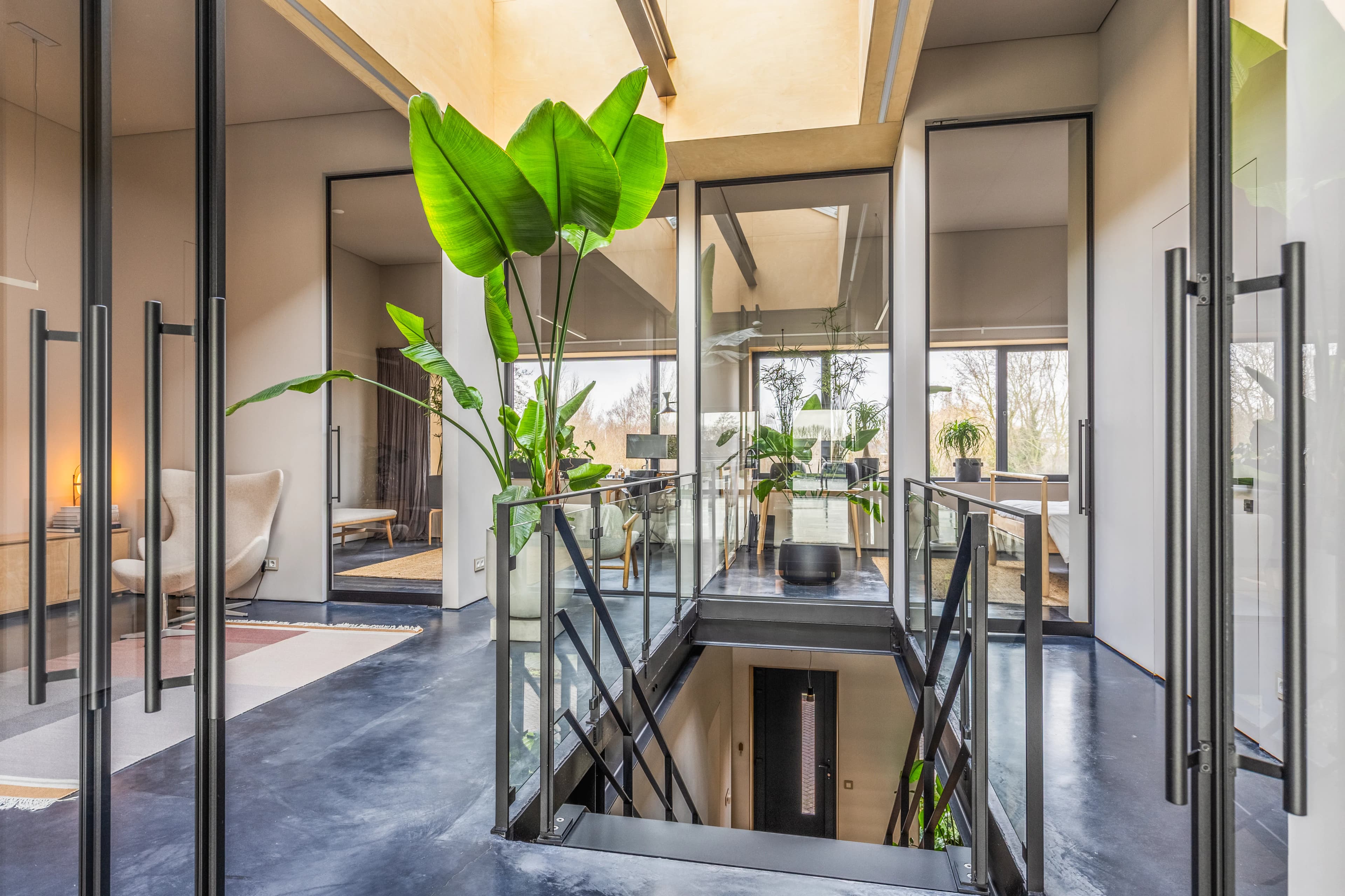Luxe villa met glazen trap, open verdieping en tropische plant, BOG vastgoedfotografie