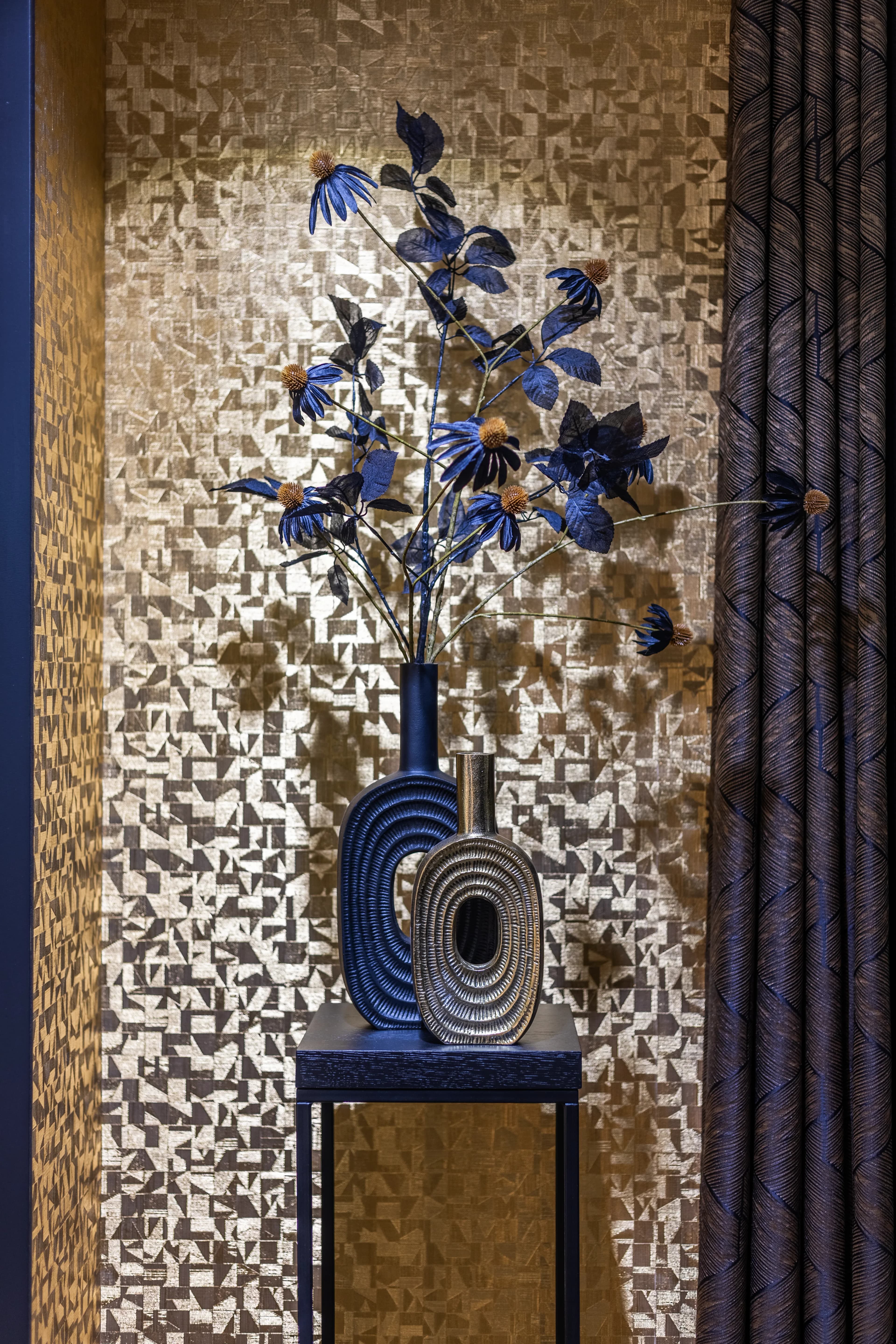 Metallic vaas met blauwe bloemen voor gouden mozaiek achtergrond, sfeer detail vastgoedfotografie