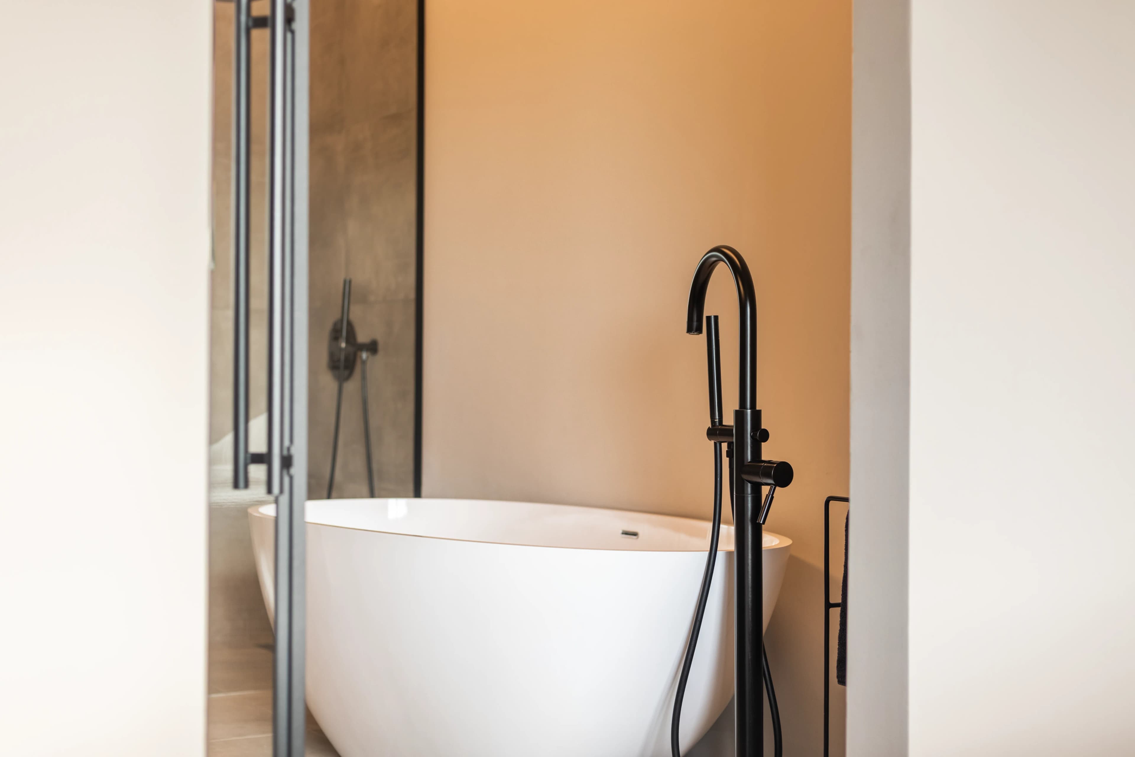 Minimalistische badkamer met vrijstaand bad en zwarte kraan, interieur vastgoedfotografie