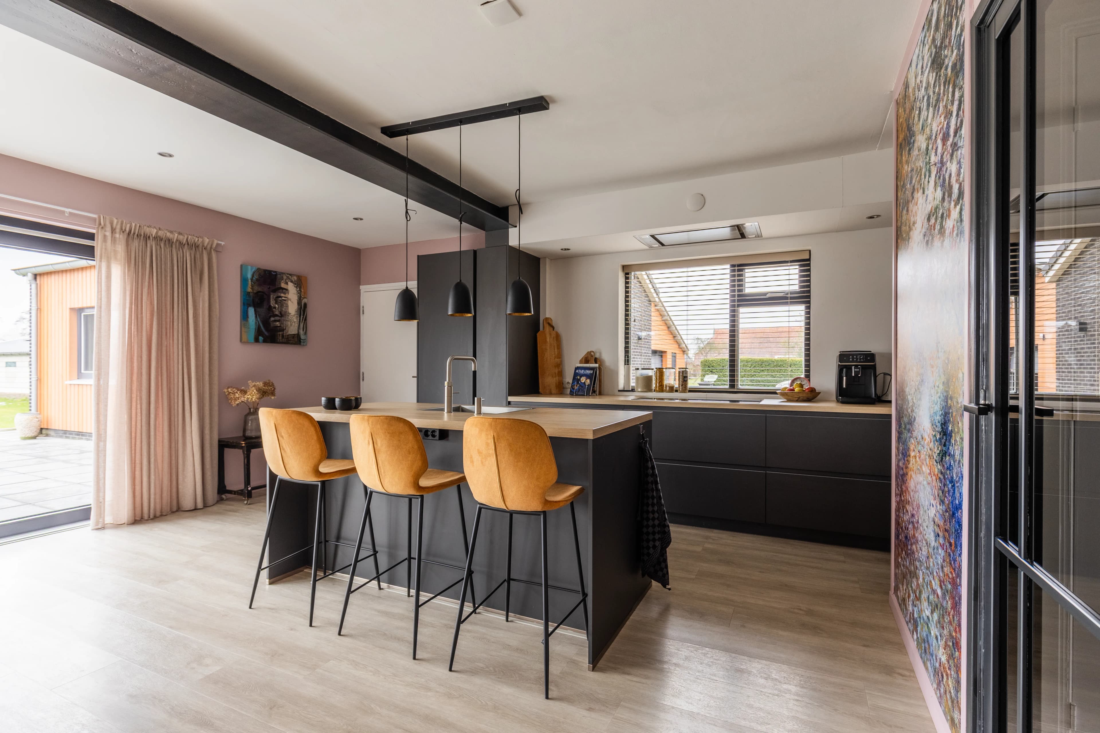 Moderne keuken met barhoek, okergele barkrukken en abstract schilderij, vastgoedfotografie