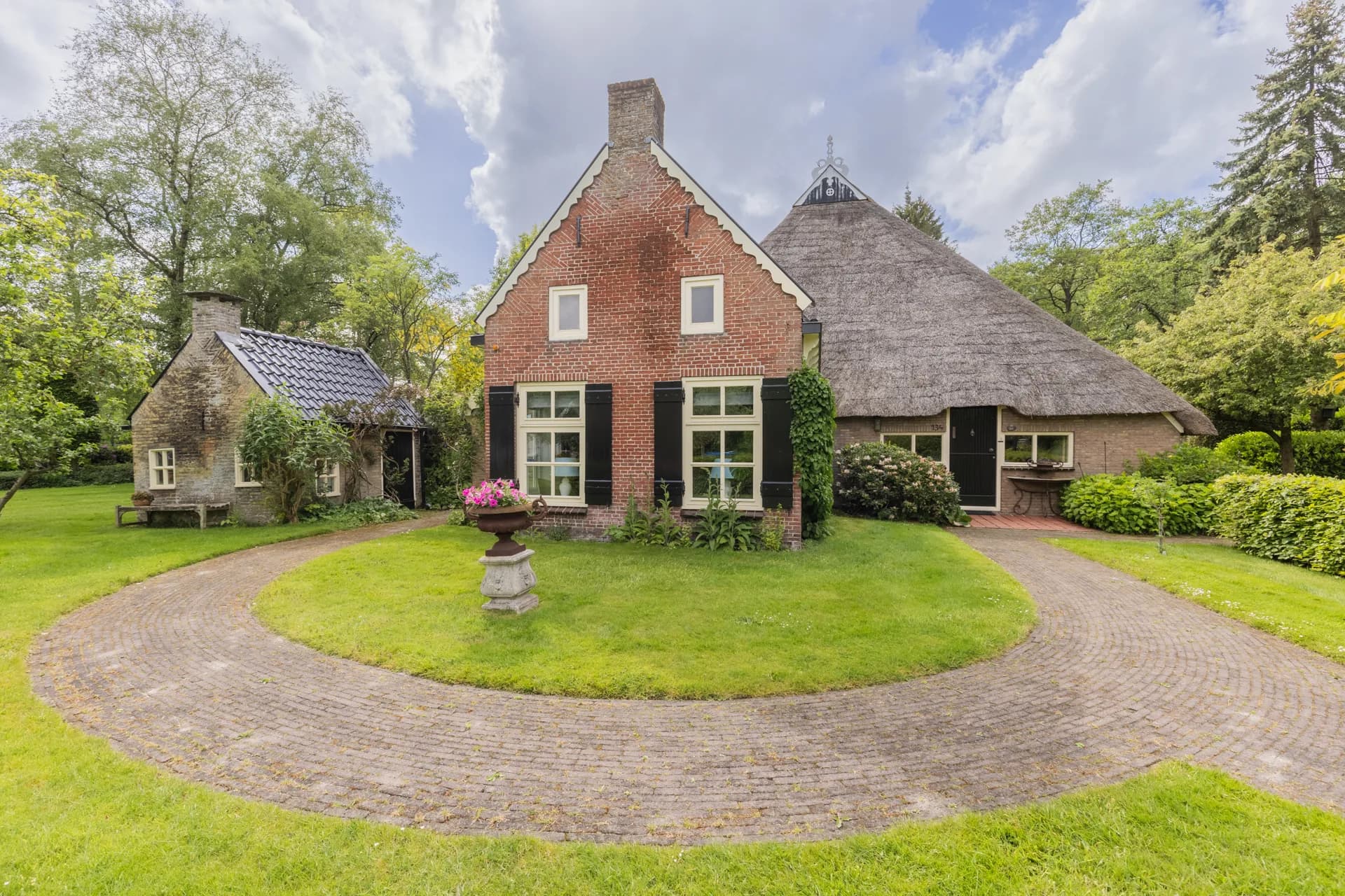 Friese boerderij met rieten dak, ronde oprit en tuinornament, vastgoedfotografie Friesland