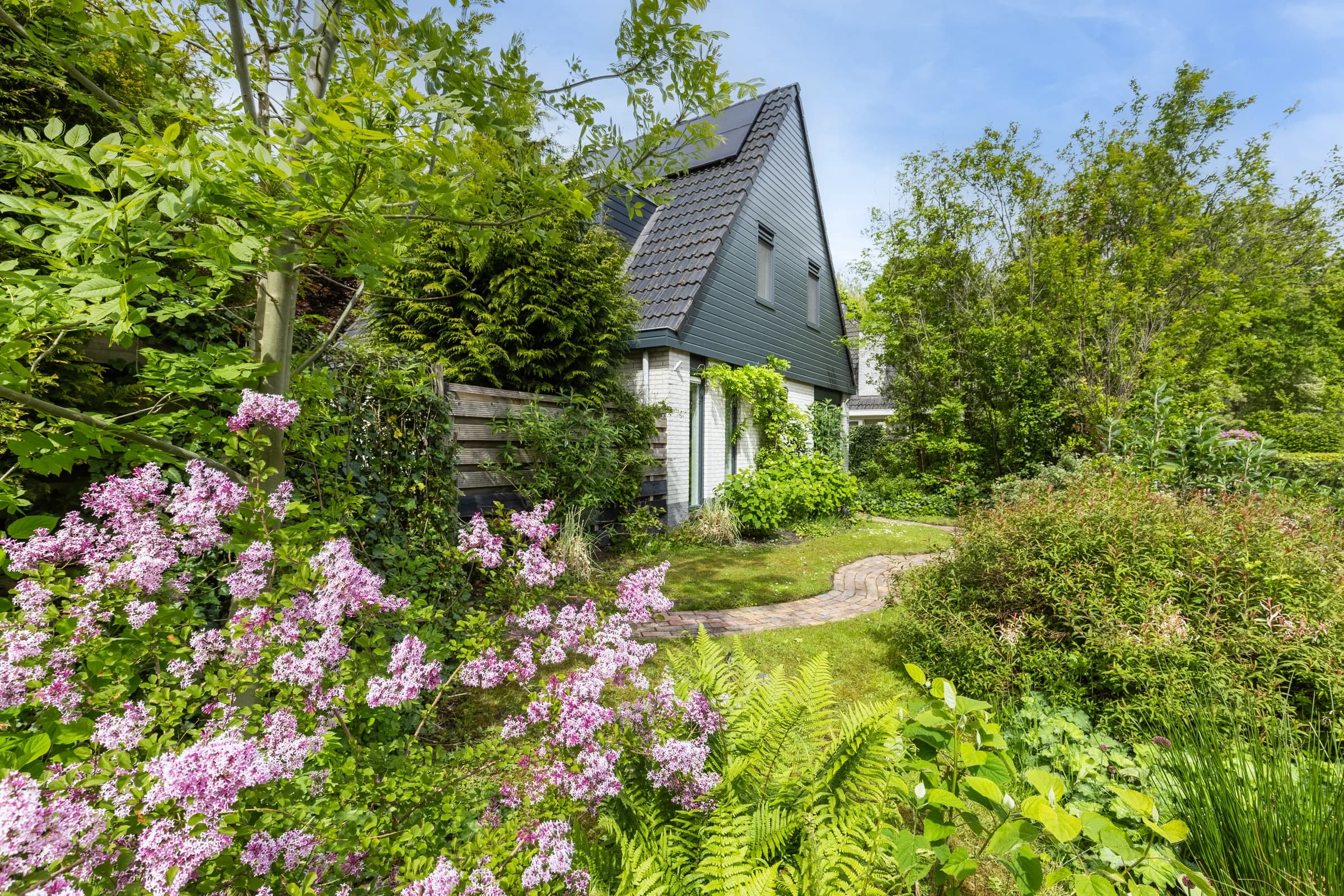 Woning omgeven door bloeiende tuin, vastgoedfotografie Friesland